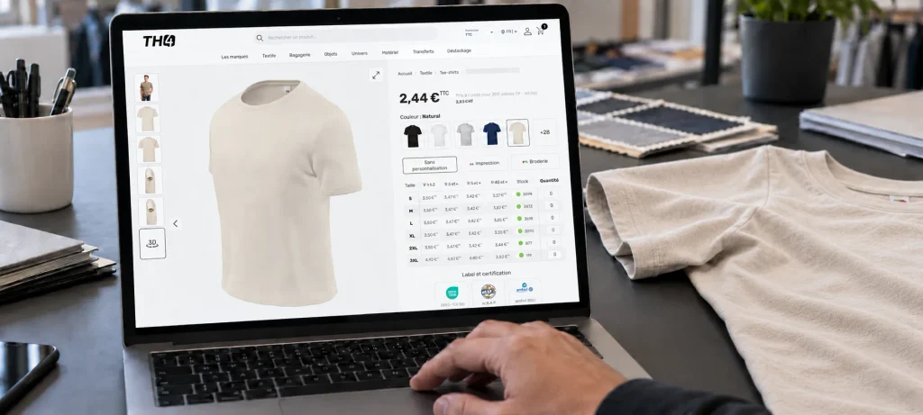 Bærbar computer viser produktside for beige T-shirt med størrelser og lagerstatus